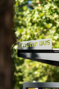 A group of matching signs with consistent colors and logos displayed along a community park pathway.