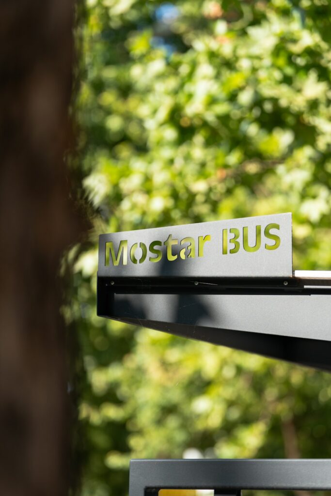 A group of matching signs with consistent colors and logos displayed along a community park pathway.