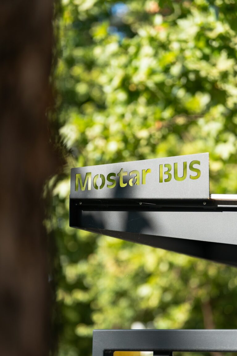 A group of matching signs with consistent colors and logos displayed along a community park pathway.