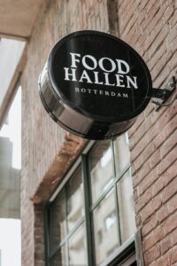 Dimensional restaurant lettering above an entrance with clear contrast and subtle evening illumination.